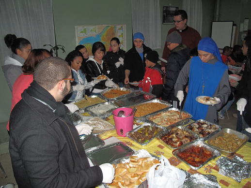 Seminarian Carlos Velasquez and Sisters Mary Our Lady of Peace Villanueva, S.S.V.M., and Maria Corona, S.S.V.M., above, assist youth ministers from SS. Peter and Paul, Williamsburg, in serving food to the men who come to the South Side Community Center for dinner.
