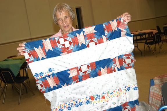Peggy Moerler displays one of her handmade quilts. (Photo © Marie Elena Giossi)