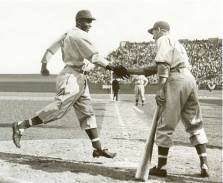 Montreal Royals outfielder George Shuba, right, shakes Jackie Robinson’s hand after the latter hit a home run on April 18, 1946 in Jersey City, N.J. (Photo courtesy George Shuba Official Website)
