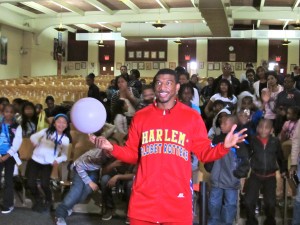 Anthony “Buckets” Blakes of the Harlem Globetrotters poses with children from Catholic Charities Brooklyn and Queens’ Out of School Time program in the auditorium of Bishop Ford H.S., Park Slope. (Photo by Jim Mancari)