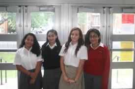 New McClancy students, from left, Tatiana Plasencia, Kayla Johnson, Davina Saltos and Alexia Mikellides pose in the school’s lobby on their first full day of school. (Photo by Jim Mancari)