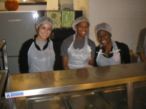 St. John’s student-athletes, from left, Mariana Barrios, Stephanie Barnes and Rikka Lovely graciously served meals at Bread and Life the day before Thanksgiving. (Photo courtesy St. John's Athletic Communications)