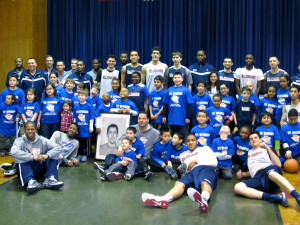 The St. Francis College men’s basketball team and participants in the St. Ephrem’s parish “Swish for Kids” basketball classic pose with a portrait of Frankie Loccisano, the namesake of a charitable organization that fights pediatric cancer. (Photo by Jim Mancari)