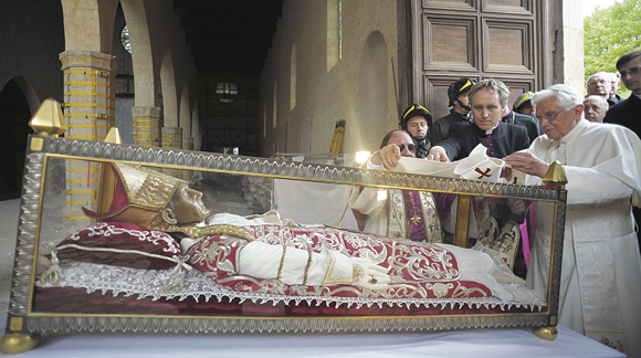 Pope Benedict XVI places a white stole on the remains of 13th-century Pope St. Celestine V during his 2009 visit to the earthquake-damaged Basilica of Santa Maria di Collemaggio in L’Aquila, Italy. Pope Benedict said he would resign at the end of the month because he no longer has the energy to exercise his ministry over the universal Church. St. Celestine V, a hermit who was elected at the age of 80 and became overwhelmed by the office, was the last pope freely to resign from the papacy.
