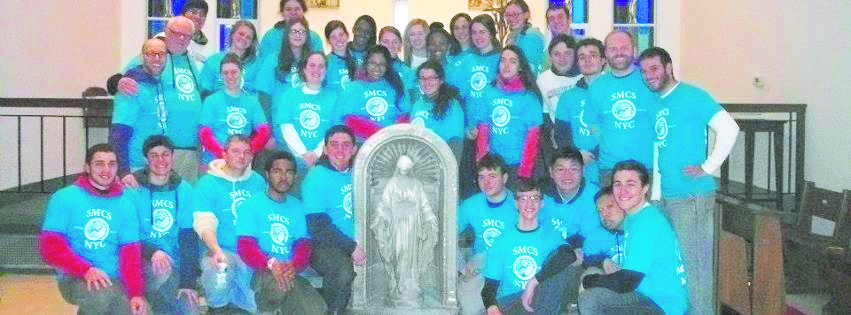 The St. Marcellin Champagnat Society of Archbishop Molloy H.S., Briarwood, concluded their volunteer week in Breezy Point with a Mass at St. Thomas More Church. After the Eucharistic celebration, the group gathered around a statue of Mary, which survived the fires caused by superstorm Sandy. This statue is now affectionately called Our Lady of Breezy Point by the members of the community.