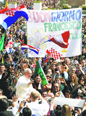 Pope Francis greets the crowd as he leaves St. Peter's Square after celebrating Palm Sunday Mass at the Vatican March 24. A sign in Italian in the square wishes the pope a good day.  (CNS photo/Paul Haring) 