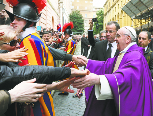 Pope Francis greets people after celebrating Mass at St. Anne's Parish within the Vatican March 17.The new pope greeted every person leaving the small church and then walked over to meet people waiting around St. Anne's Gate. (CNS photo/Paul Haring)