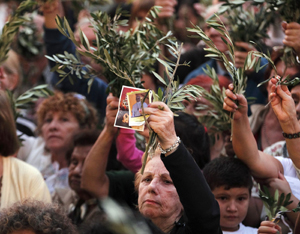 Woman holds up picture of Pope Francis outside Argentine basilica