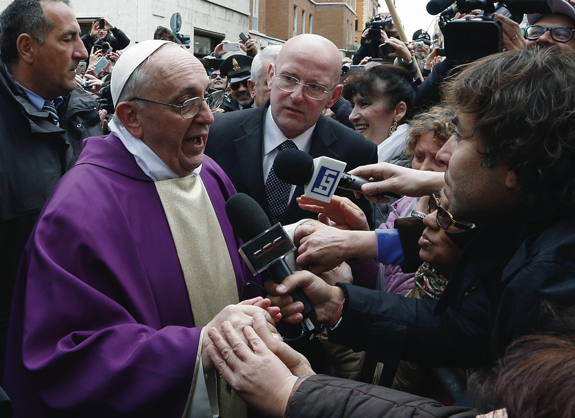 Pope Francis speaks to reporters while greeting people after celebrating Mass at St. Anne’s parish within the Vatican March 17. The new pope greeted every person leaving the small church and then walked over to meet people waiting around St. Anne’s gate.