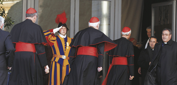 a Swiss Guard salutes as U.S. Cardinals Roger M. Mahony, retired archbishop of Los Angeles, Edward M. Egan, retired archbishop of New York, and Donald W. Wuerl of Washington enter a meeting.