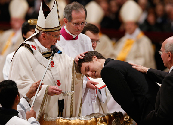 Pope Francis baptizes a young man during the Easter Vigil in St. Peter’s Basilica.