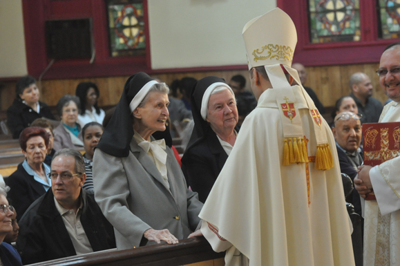 Bishop Frank Caggiano congratulates Sisters Jean Philip  Brady, C.S.J., and Sister Miriam Morgan, C.S.J., at Epiphany Church, Williamsburg. One of the three renovated parish halls was named in honor of the sisters who each spent more than 40 years at the parish.
