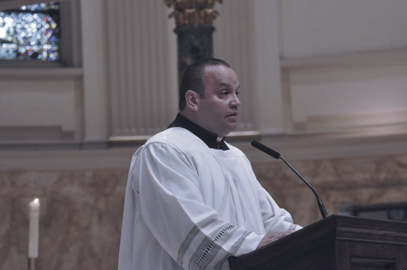Msgr. Anthony Hernandez, diocesan chancellor, reads the decree establishing the deanery system during vespers at St. James Cathedral-Basilica, Downtown Brooklyn.