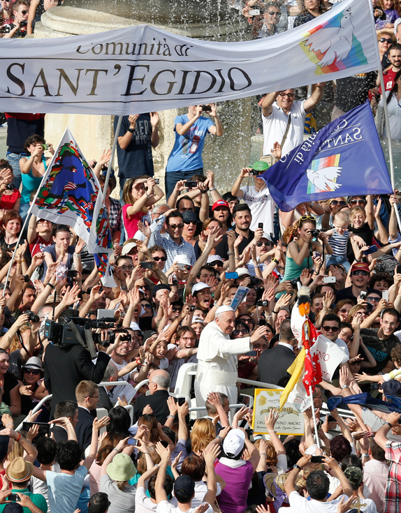 A sign for the Sant’Egidio Community is seen as Pope Francis arrives for a Pentecost prayer vigil with members of Catholic lay movements in St. Peter’s Square at the Vatican May 18. An estimated 200,000 people from 150 movements attended the vigil.