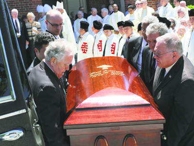 Pallbearers place the casket of Bishop Sullivan into a hearse following the bishop's funeral.
