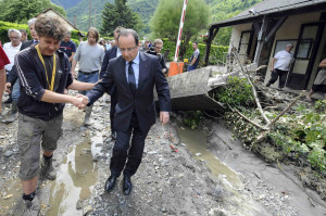 French President Francois Hollande is assisted as he walks in a damaged street of Saint-Beat in southwestern France June 20, two days after the village was submerged by flash floods. Heavy flooding in southwestern France killed three people and forced the closure of the Shrine of Our Lady of Lourdes for the second time in eight months. 