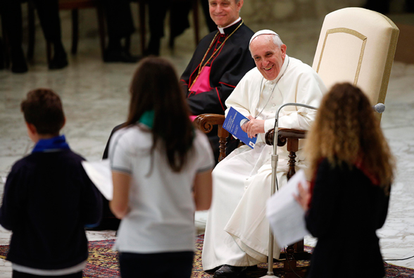 Pope Francis smiles during a special audience with students from Jesuit schools June 7 in Paul VI hall at the Vatican.
