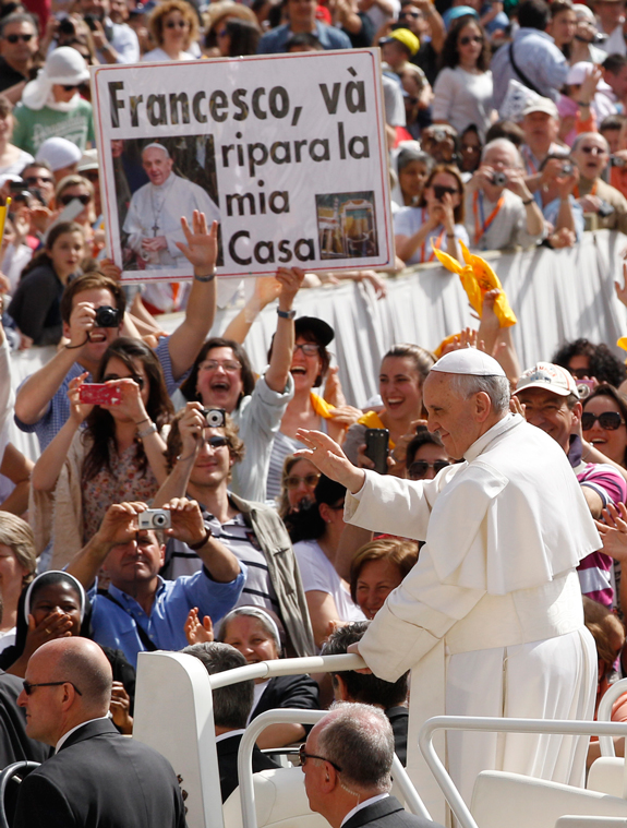 Pope Francis greets the crowd as he arrives to lead his general audience in St. Peter’s Square at the Vatican May 1. The sign in the crowd in Italian says “Francesco, go rebuild my house,” a reference to Jesus’ words to St. Francis in an apparition.
