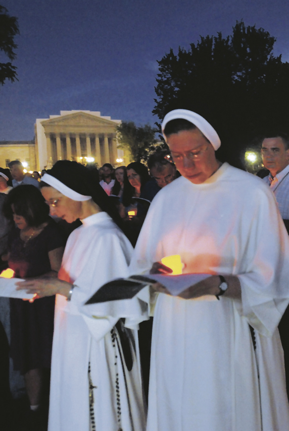 The U.S. Supreme Court is seen in the background as nuns and others pray during a candlelight vigil for the second annual Fortnight for Freedom observance outside the U.S. Capitol in Washington, D.C., June 22. 