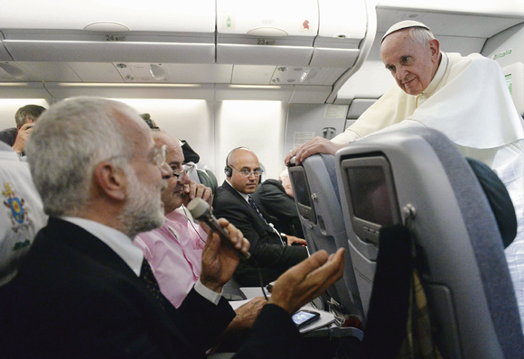 Pope Francis listens to a question from a journalist on his flight heading back to Rome July 29. The pope answered questions from 21 journalists over a period of 80 minutes on his return from Brazil.