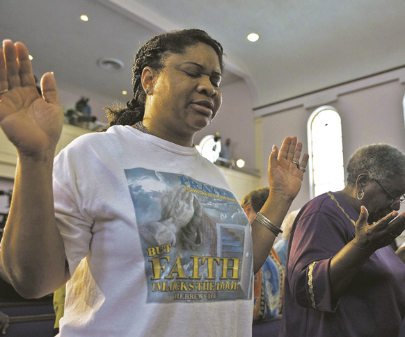 Women pray during a July 15 service at the New Life Word Center Church in Sanford, Fla., led by a coalition of local ministers in an effort to move the community past the George Zimmerman murder trial and verdict. After Zimmerman’s July 13 acquittal in the Trayvon Martin murder trial in Sanford, attention has now turned to how churches and communities can help heal the societal wounds of racism.