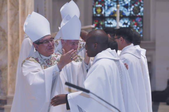 Bishop Octavio Cisneros offers a sign of peace to newly-ordained Father Dwayne Davis.