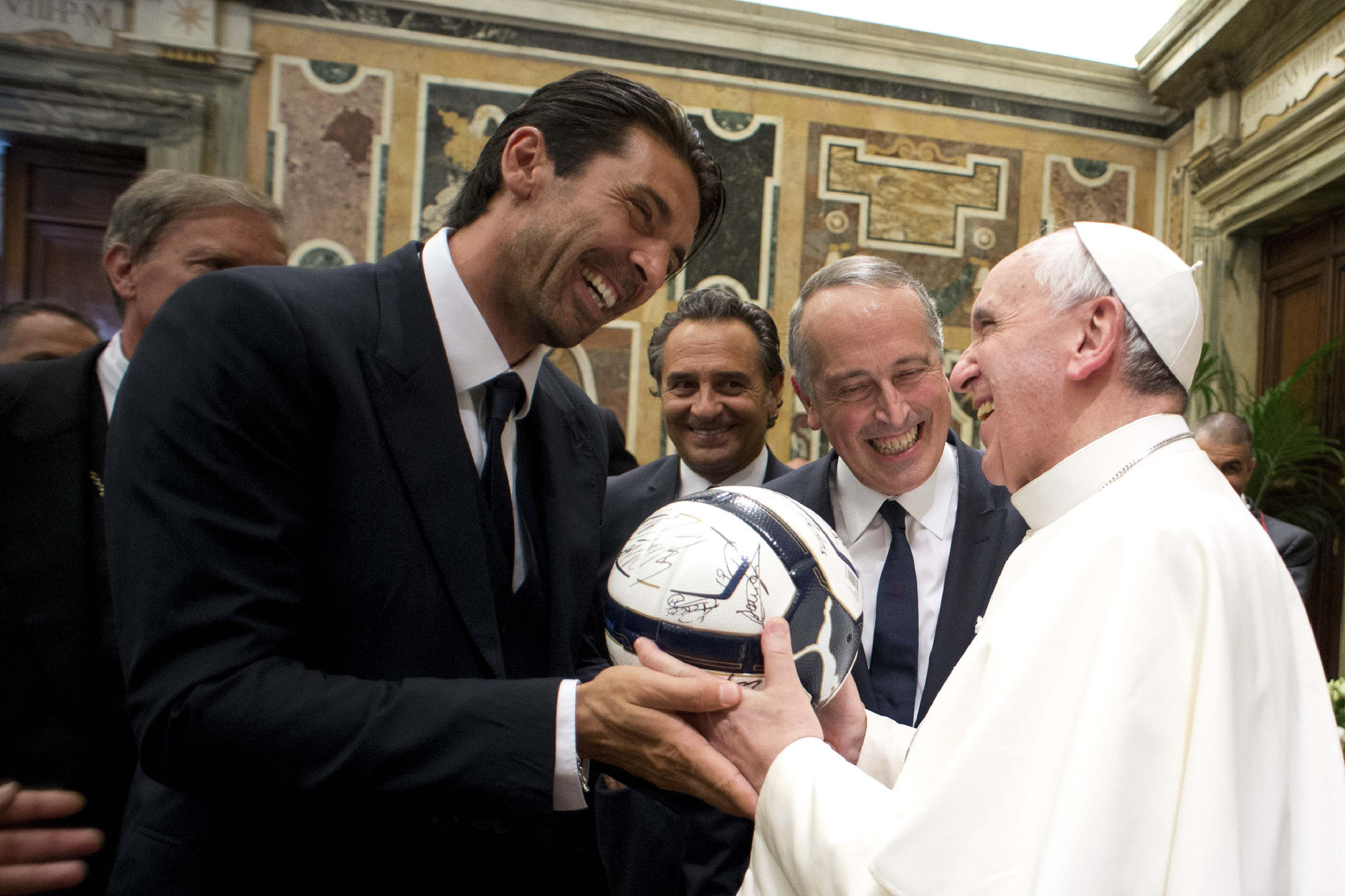 Pope Francis receives a soccer ball as gift from Italy's goalkeeper and captain, Gianluigi Buffon, during a private audience at the Vatican Aug. 13. Argentina will play Italy in a friendly soccer match Aug. 14 in the pope's honor. (CNS photo/L'Osservatore Romano via Reuters) 