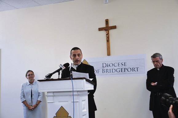 Bishop Caggiano speaks to the press in Bridgeport while Msgr. Jerald Doyle, apostolic administrator, and Anne O. McCrory, Esq., Chancellor, look on.