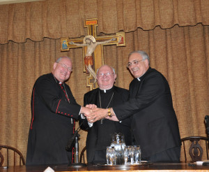 Then-Archbishop Timothy Dolan, Bishop William Murphy and Bishop Nicholas DiMarzio join hands after signing an historic agreement to unite their major seminary programs in November, 2011.