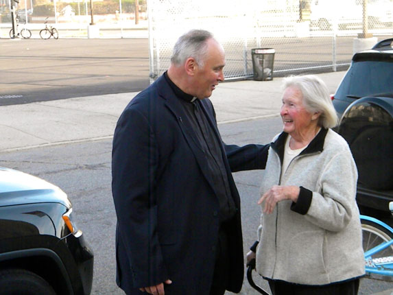 Msgr. John Brown, former pastor of St. Francis de Sales, Belle Harbor, was welcomed back to the parish by a parishioner and school children.  Oct. 29 marked the first anniversary of the arrival of Hurricane Sandy, which devastated the area.