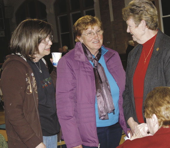One year after Hurricane Sandy, Mary Bunyan, left, reflects on that experience with a fellow parishioner from St. Francis de Sales, Belle Harbor, and Sisters Patricia Ann Chelius, C.S.J., standing, and Patricia Walsh, C.S.J., seated.