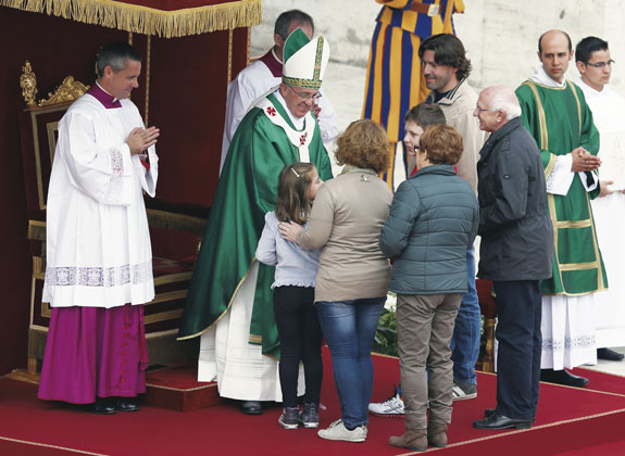 Pope Francis greets a family as they present the offertory gifts during a Mass for families in St. Peter’s Square at the Vatican on Oct. 27.