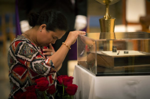 A woman prays next to relics of St. Therese of Lisieux Oct. 3 at the Basilica of the National Shrine of the Immaculate Conception in Washington. The beloved saint's small wooden writing case, along with her pen and inkwell, were in  America for the first time in a tour organized by the Pontifical Mission Societies of the United States. St. Therese is patron of missionaries and missions. (CNS photo/Nancy Phelan Wiechec)