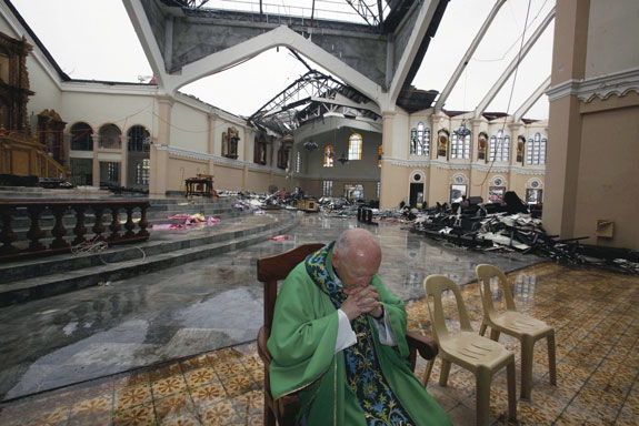 Cardinal Theodore E. McCarrick, retired archbishop of Washington, D.C., prays during a Mass inside the partially destroyed Cathedral of the Transfiguration of Our Lord in Palo, Philippines, Nov. 17. Cardinal McCarrick celebrated Mass at the heavily damaged cathedral for victims of Typhoon Yolanda, which came ashore Nov. 8 in the Philippines.