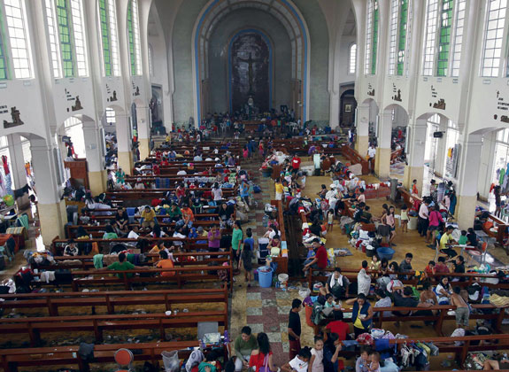 residents seek refuge inside a Catholic church converted into an evacuation center Nov. 10 in battered Tacloban.