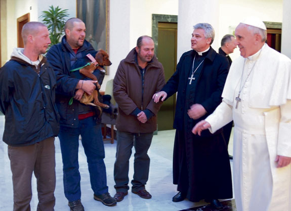 Pope Francis talks with three men who live on the streets near the Vatican, Dec. 17. As part of a low-key celebration of his 77th birthday, the pope celebrated morning Mass and had breakfast with the men.