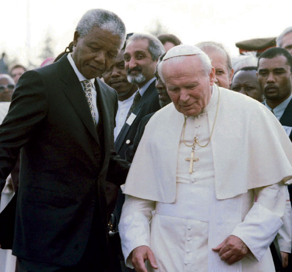 South African President Nelson Mandela assists Pope John Paul II at the Johannesburg International Airport in this 1995 file photo. Mandela, who led the struggle to replace the country’s apartheid regime with a democracy, died Dec. 5.