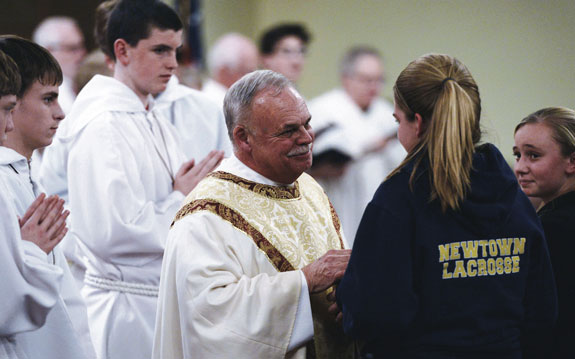 Msgr. Robert Weiss speaks to young women inside St. Rose of Lima Church during a vigil service on the evening of the day’s tragic events that unfolded one year ago in Newtown, Conn., which is in the Diocese of Bridgeport.