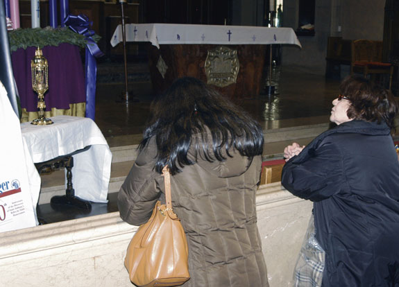 Women pray at the altar of Our Lady Queen of Martyrs Church in front of a reliquary containing St. Anthony’s rib bone, which was carried through the streets of Argentina in 2000 by Pope Francis, then-Archbishop Jorge Bergoglio.