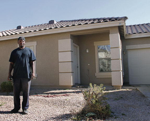 Terrance Alston poses in front of a vacant house he helped to renovate in Chandler, Ariz. He is one of 925 success stories St. Joseph the Worker social service agency could tell from helping homeless clients regain self-sufficiency in the last fiscal year alone.