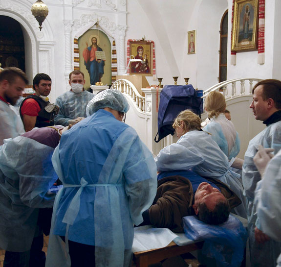 a man receives medical treatment inside St. Michael’s Orthodox Cathedral in Kiev.