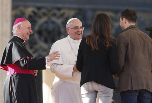Pope Francis greets Miriam and Marco, an engaged couple who spoke during an audience for engaged couples in St. Peter’s Square at the Vatican Feb. 14, St. Valentine’s Day. The pope told the couples that love means always being able to say you are sorry.