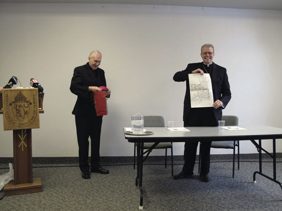 Bishop-designate Scharfenberger displays a map of the Diocese of Albany, N.Y., that was presented to him by retiring Bishop Howard Hubbard.