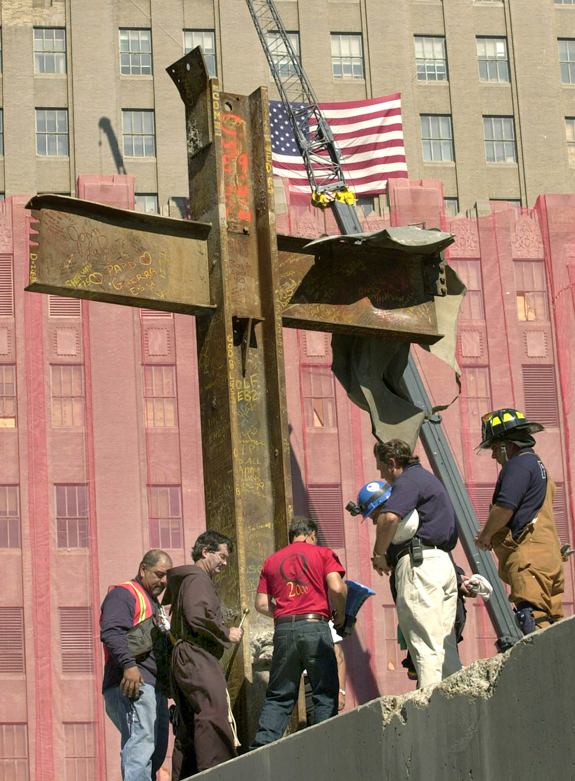 Franciscan Father Brian Jordan, standing with laborers and emergency workers in 2001, blesses a 17-foot-tall cross formed by steel beams that was recovered from the rubble of the World Trade Center in Manhattan. A group called American Atheists filed suit in federal court to have the cross removed from a permanent exhibit to be displayed in the National September 11 Memorial & Museum.