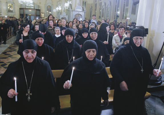 Mother Plagia Sayyaf of Mar Thecla monastery in Maaloula, Syria, left, who along with at least 11 other nuns was freed after three months, attends a prayer service at the Greek Orthodox Church of the Holy Cross in Damascus March 10. Islamist rebels claimed responsibility for the abduction of the nuns in December from Syria’s ancient town of Maaloula.