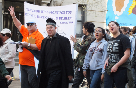 Msgr. Perfecto Vazquez, above center, spiritual director of the Cursillos de Cristiandad, marched with over 400 Jornadistas through the streets of Manhattan on Holy Saturday. Below, left, Jornadistas from St. Patrick Church, Long Island City, and at right, All Saints Jornada Group, Williamsburg, with the banner for Guardian Angel parish, Brighton Beach, just behind them.