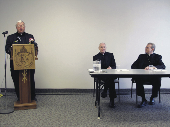 Father Kenneth Doyle, director of communications for the Diocese of Albany, N.Y., introduces Bishop-elect Scharfenberger at a press conference on the day he was appointed as Bishop of Albany. Seated in the middle is the retiring Bishop Howard J. Hubbard.