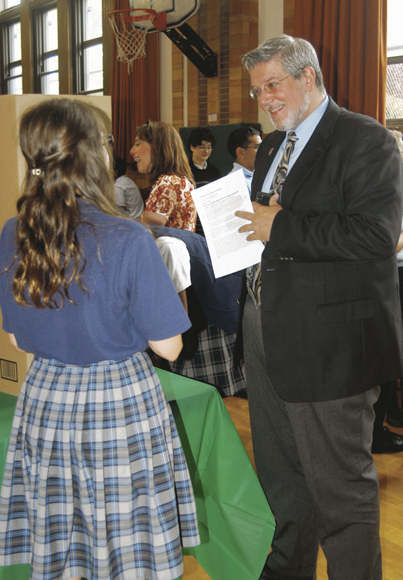 Anthony Biscione, deputy superintendent of diocesan Catholic schools, right, listens as a student explains her group’s project.