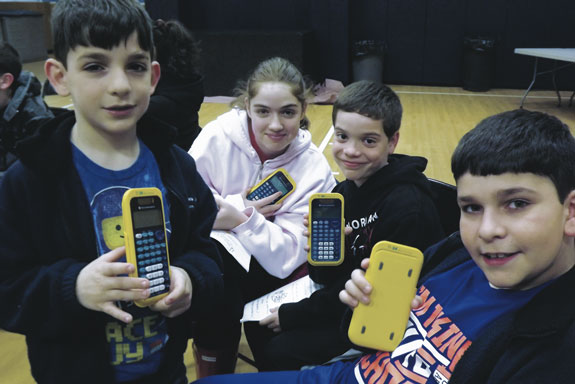 Students from Ave Maria Academy show off their calculators at the school’s second annual Family Math Night.