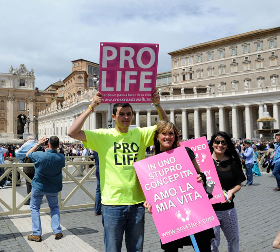 Young people display signs during a May 4 pro-life demonstration in St. Peter’s Square at the Vatican. According to organizers, more than 50 pro-life groups active in some 20 countries took part in the march. 